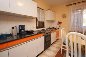 a kitchen with white cabinets and a stove top oven at Holiday house with a parking space Presika, Labin - 7391 in Labin