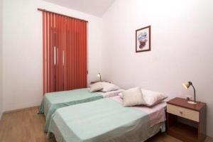 a bedroom with two twin beds and a red door at Apartments with a swimming pool Valbandon, Fazana - 7351 in Fondole