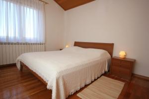 a bedroom with a white bed and a window at Apartments with a parking space Presika, Labin - 7390 in Labin