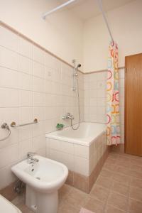 a bathroom with a sink and a tub and a toilet at Apartments with a parking space Presika, Labin - 7390 in Labin