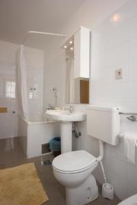 a white bathroom with a toilet and a sink at Apartments with a parking space Presika, Labin - 7390 in Labin