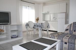 una sala de estar blanca con mesa y sillas en Family friendly apartments with a swimming pool Valbandon, Fazana - 7346, en Fažana