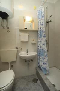 y baño con aseo, lavabo y ducha. en Family friendly apartments with a swimming pool Valbandon, Fazana - 7346, en Fažana