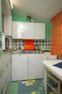 eine kleine Küche mit weißen Schränken und einem Tisch in der Unterkunft Apartments with a parking space Valbandon, Fazana - 7383 in Fondole