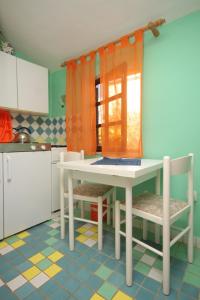 a kitchen with a table and chairs in a kitchen at Apartments with a parking space Valbandon, Fazana - 7383 in Fondole