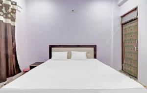 1 dormitorio con cama blanca y ventana en Hotel Krishna Palace & Restaurant By WB Inn, en Agra