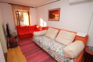 salon z kanapą i czerwoną sofą w obiekcie Holiday house with a parking space Pomer, Medulin - 7344 w Medulinie