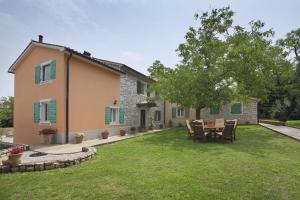 a house with a table and chairs in the yard at Family friendly apartments with a swimming pool Sumber, Central Istria - Sredisnja Istra - 7332 in Nedeščina