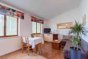 un soggiorno con tavolo e divano di Family friendly apartments with a swimming pool Krnica, Marcana - 7357 a Krnica