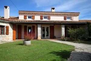 ein Haus mit einem grünen Hof davor in der Unterkunft Luxury villa with a swimming pool Kavran, Marcana - 7311 in Krnica