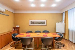 una sala de conferencias con mesa de madera y sillas en Hotel Medici, en Roma