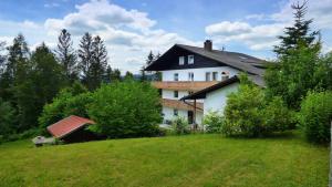 a house sitting on top of a green hill at Haus der 5 Kontinente in Böbrach