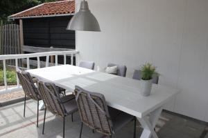 een witte tafel met stoelen en een potplant bij Lodge21Ouddorp in Ouddorp