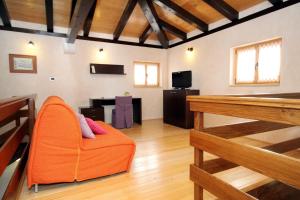 Una sala de estar con un sofá naranja y una mesa de billar. en Family friendly house with a swimming pool Kanfanar, Central Istria - Sredisnja Istra - 7330, en Kanfanar