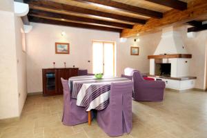 salon ze stołem i fioletowymi krzesłami w obiekcie Family friendly house with a swimming pool Kanfanar, Central Istria - Sredisnja Istra - 7330 w mieście Kanfanar