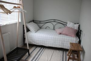 a bedroom with a white bed with a pink pillow at Lodge21Ouddorp in Ouddorp