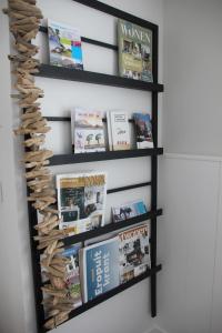 een boekenplank gevuld met boeken en tijdschriften bij Lodge21Ouddorp in Ouddorp