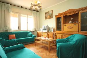 a living room with two blue couches and a tv at Apartments with a parking space Pula - 7321 in Valdebek
