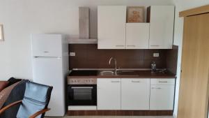 a kitchen with white cabinets and a sink and a stove at Apartments with parking space Valbandon, Fazana - 7305 in Valbandon