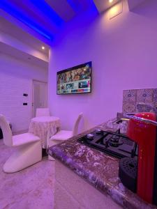 Habitación púrpura con cocina con fogones y mesa. en GianLuis Luxury Suites en Fasano