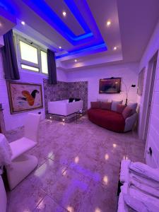 uma sala de estar com iluminação roxa e um sofá e cadeira em GianLuis Luxury Suites em Fasano