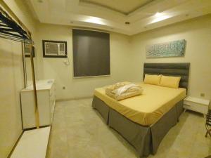 a bedroom with a bed and a chalkboard on the wall at Kayan Apartments in Jeddah