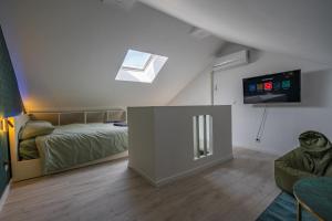 1 dormitorio con 1 cama y TV de pantalla plana en Capstay la Rhonelle - Netflix - 2 chambres - Cuisine, en Valenciennes