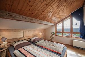 a bedroom with a large bed with a wooden ceiling at Schwarzwald Ferienwohnung Stefan *Idyllische Lage *Sauna *Luftkurort *Wanderwege in Loßburg