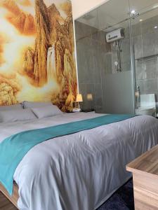 a bedroom with a large bed with a painting on the wall at Hotel My Cang in Trà Vinh