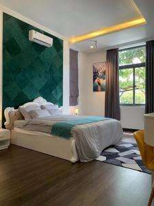 a bedroom with a large bed with a green wall at Hotel My Cang in Trà Vinh