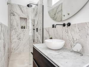 a bathroom with a sink and a shower with a mirror at STAYSOME Amsterdam Hemonystraat in Amsterdam