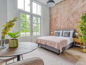 een slaapkamer met een bed en een bakstenen muur bij limehome Amsterdam Hemonystraat - Digital access in Amsterdam