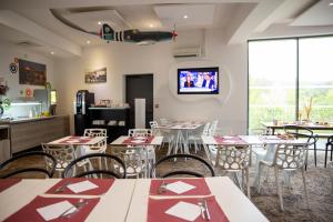 a restaurant with tables and chairs and a tv on the wall at Toulouse Fluvia in Toulouse