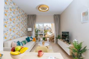 a living room with a couch and a table at Amazing renovated pool view Apt, Aircon, 2 min to Fañabe Beach in Adeje