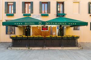 un hôtel avec un parasol vert en face d'un bâtiment dans l'établissement Hotel Santa Marina, à Venise