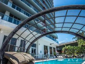 a metal canopy over a swimming pool in a building at Ocean View 2BR 2BTH Hallandale Beach Miami Ft Lauderdale in Hallandale Beach