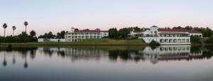 un gran edificio blanco en el borde de un lago en Asara Wine Estate & Hotel en Stellenbosch