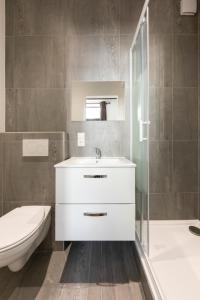 a bathroom with a sink and a toilet and a tub at IQS Rooms - Chambre double avec salle de bain in Luxembourg