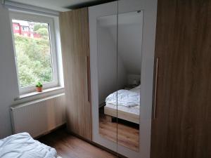 a bedroom with a glass door with a window at Ferienwohnungen Untermühle, Rothenbergerstr. 12 in Altenau