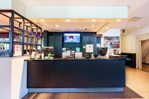 a bar in a restaurant with a counter at Bastion Hotel Rotterdam Zuid in Rotterdam