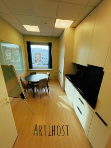 an empty room with a table and a kitchen at Artihost in Panevėžys