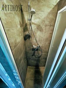 a shower stall in a bathroom with the words artifact at Artihost in Panevėžys