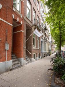 een lege straat voor een bakstenen gebouw bij limehome Amsterdam Hemonystraat - Digital access in Amsterdam