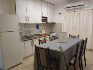 フェデラシオンにあるCasa de Juanのキッチン(テーブル、椅子、白い冷蔵庫付)