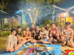 a group of people sitting around a table with food at Homestay De la Rosa - Côn Đảo in Con Dao