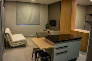 Cette chambre dispose d'une cuisine avec une table et des chaises. dans l'établissement NOVOS apartamentos STUDIO do ladinho do Paraguai, à Foz do Iguaçu