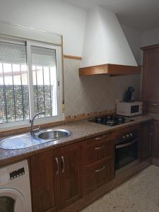 cocina con fregadero, fogones y ventana en Casa vistas al mar, en El Palmar