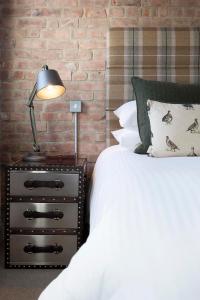 1 dormitorio con cama y mesita de noche con lámpara en The Gannet Inn, en St Ives