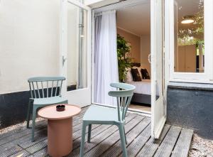 twee stoelen en een tafel op een veranda met een bed bij limehome Amsterdam Hemonystraat - Digital access in Amsterdam