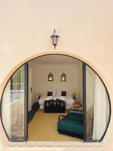 Cette chambre comprend deux lits et un grand miroir. dans l'établissement MORO Marrakech Boutique Hôtel, à Marrakech